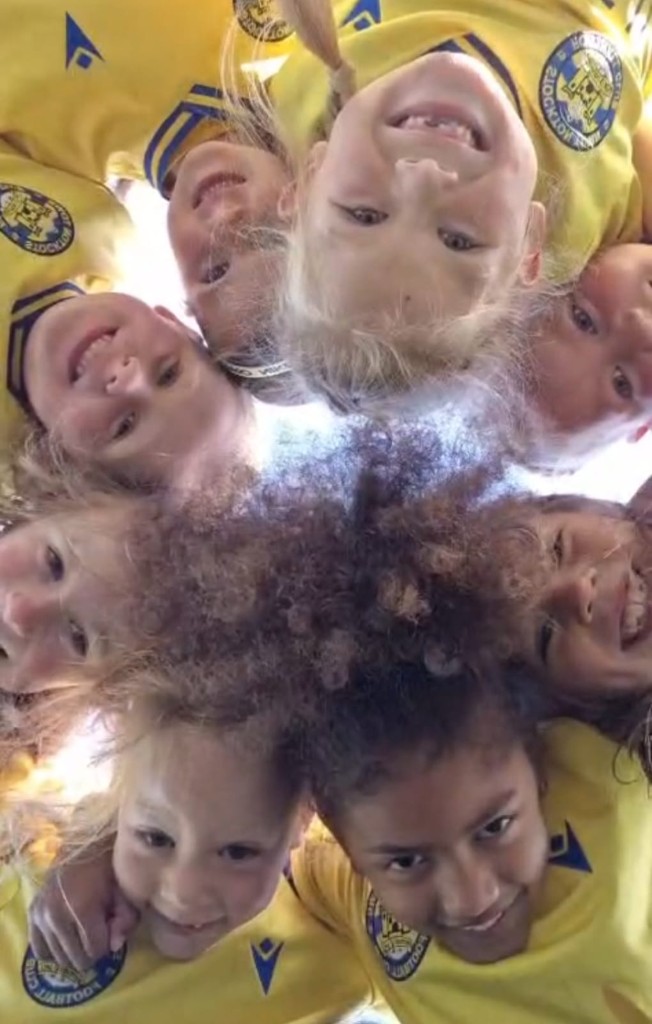 Grassroots girls football team celebrating